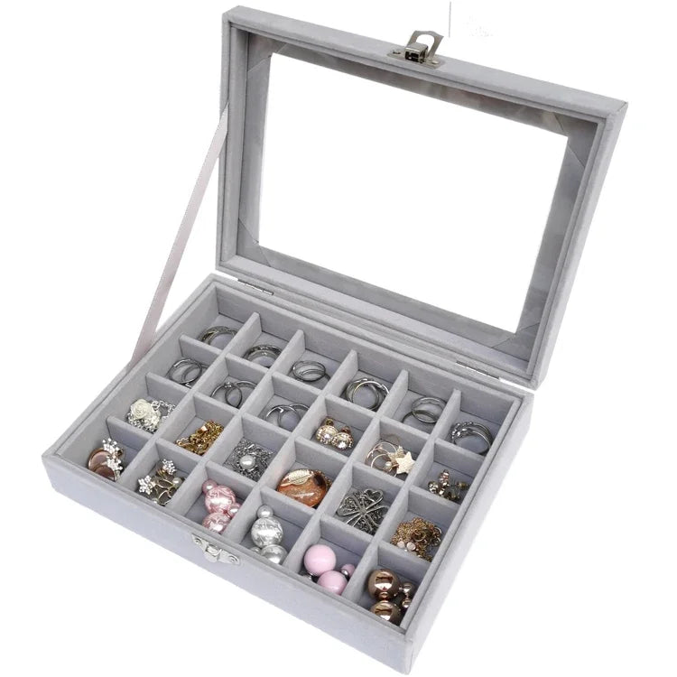 Gray velvet jewelry organizer box with transparent glass lid, featuring 24 slots for rings, earrings, and small accessories
